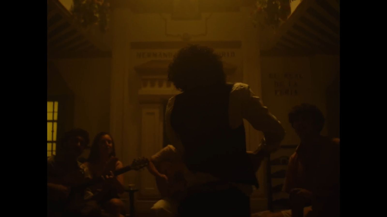 a person playing a guitar in a dark room