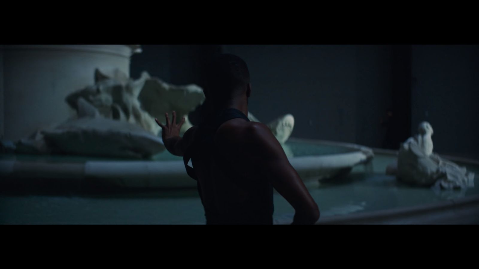 a woman standing in front of a fountain in a dark room