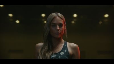 a woman in a tank top standing in a dark room