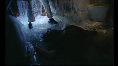 a person laying on a bed covered in plastic