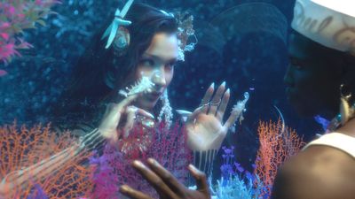 a man and a woman standing in front of a fish tank