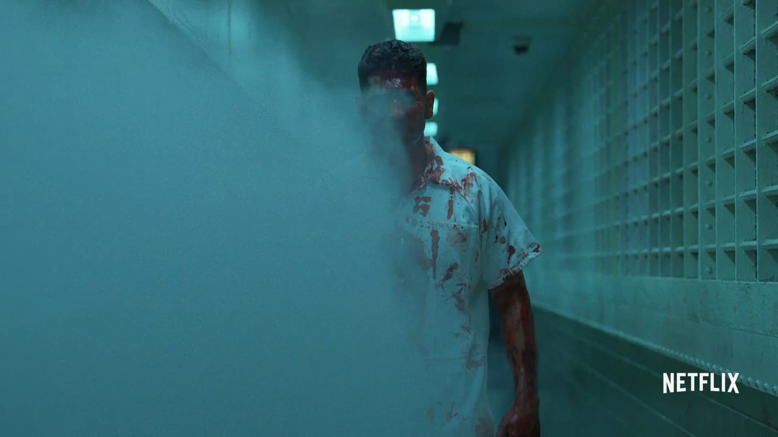 a man standing in a hallway covered in blood