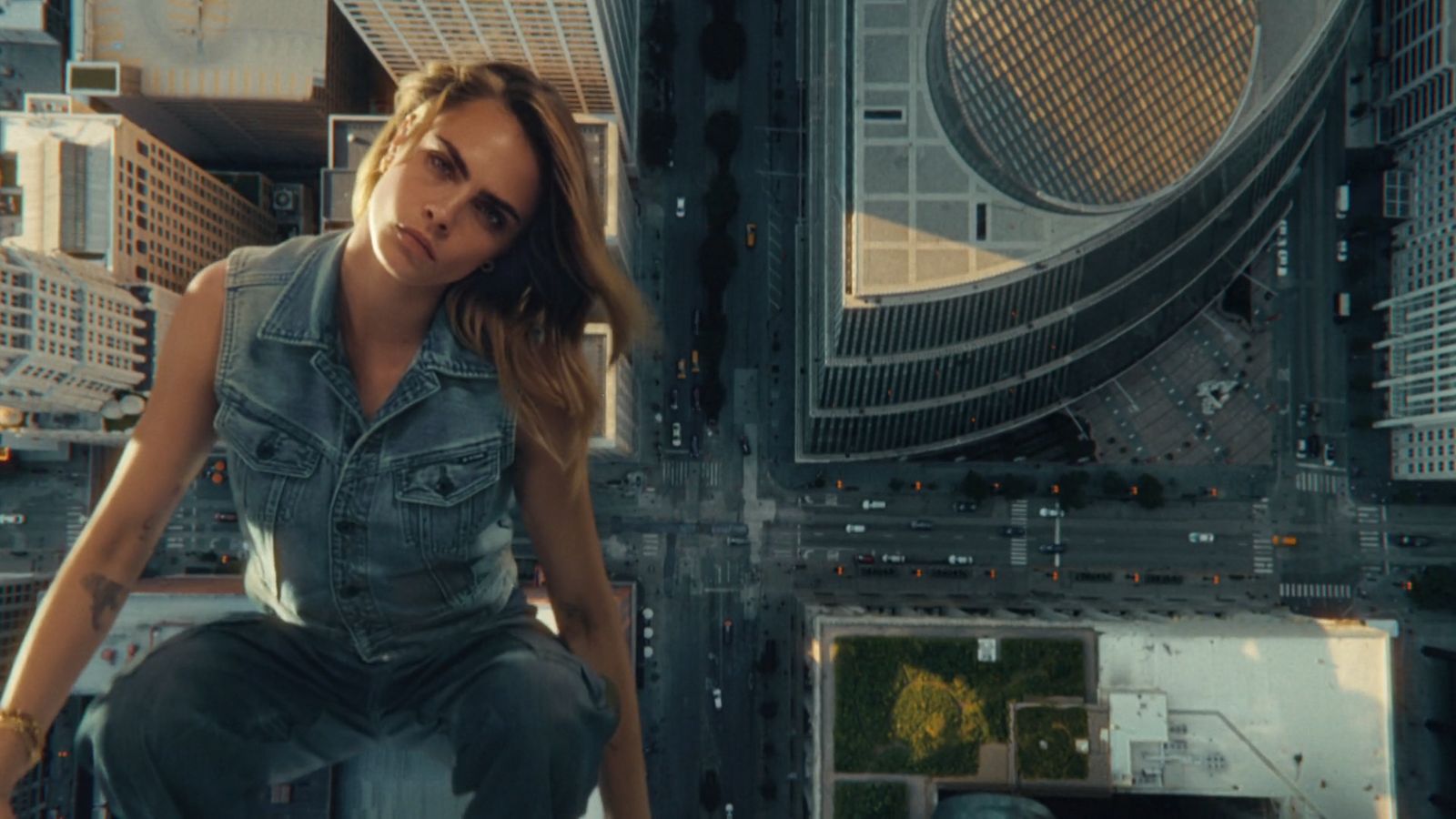 a woman sitting on top of a tall building