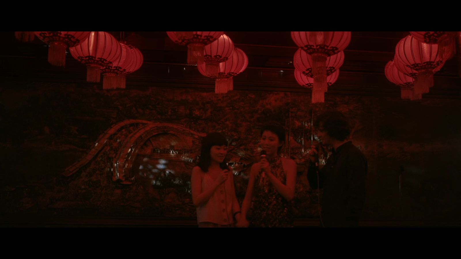 a man and a woman standing in front of red lanterns