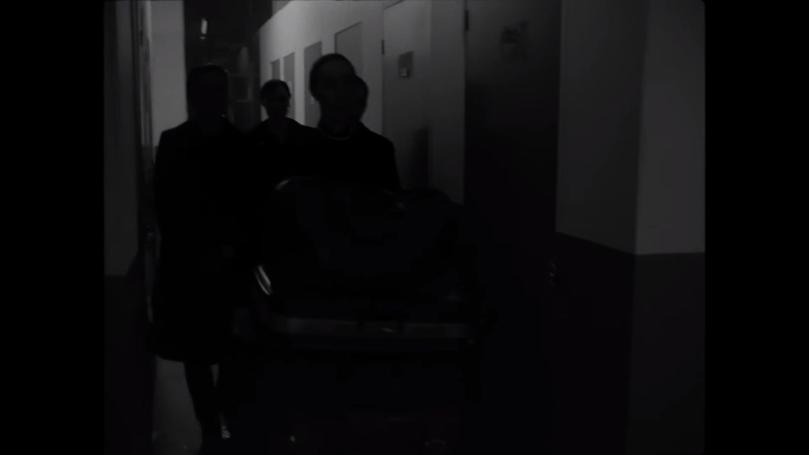 two people walking down a hallway in the dark