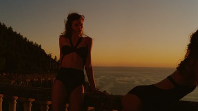 a woman in a bikini standing next to another woman