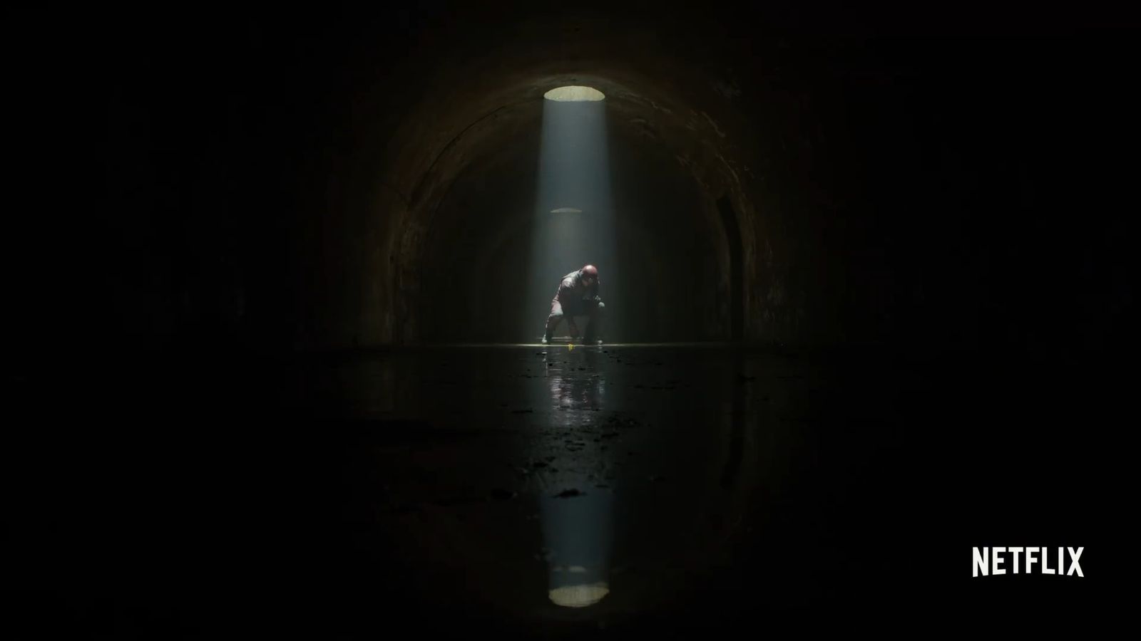 a person standing in a dark tunnel with a flashlight