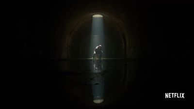 a person standing in a dark tunnel with a flashlight