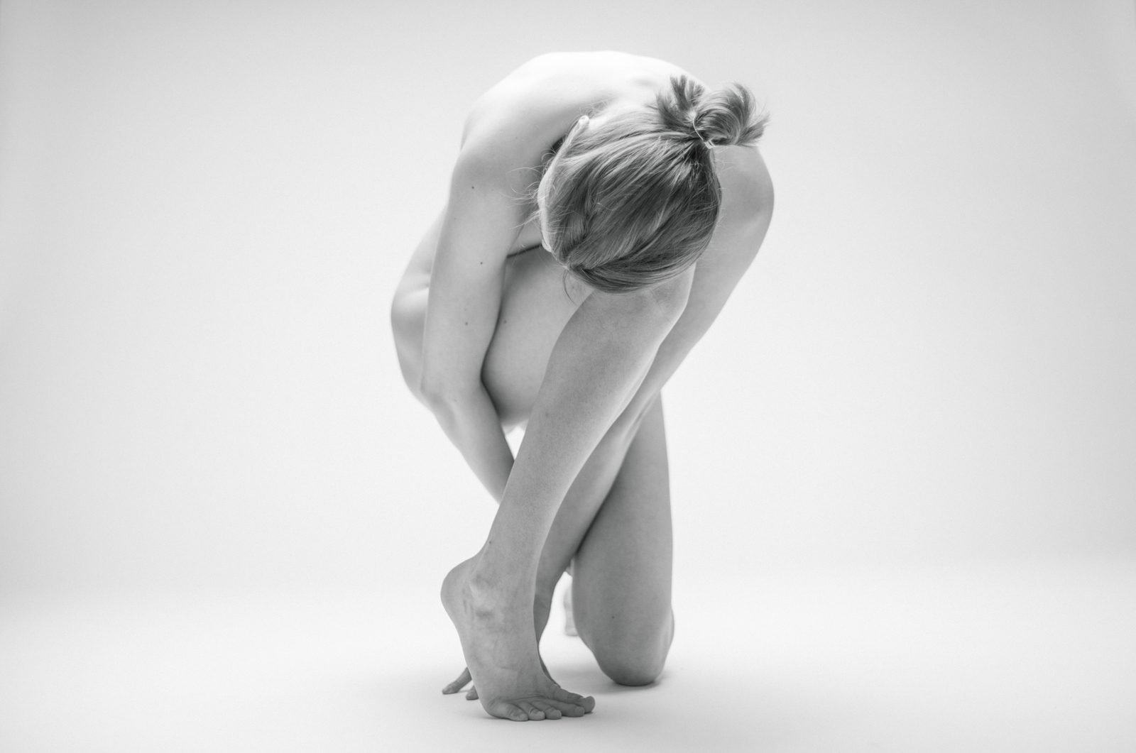 a black and white photo of a woman bending over