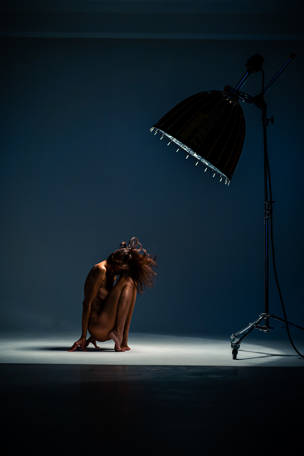 a woman kneeling down in front of a lamp