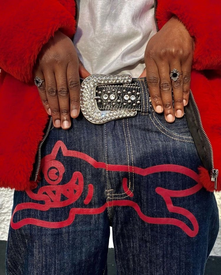 a woman in a red jacket is holding a belt