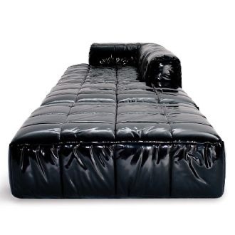 a black leather couch with a black pillow on top of it