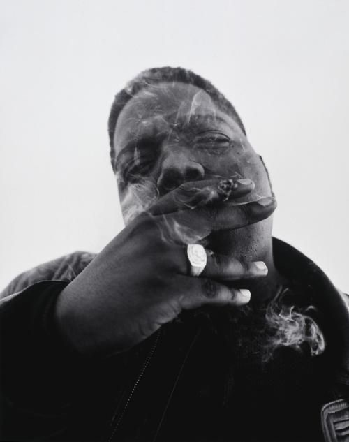 a man smoking a cigarette in a black and white photo