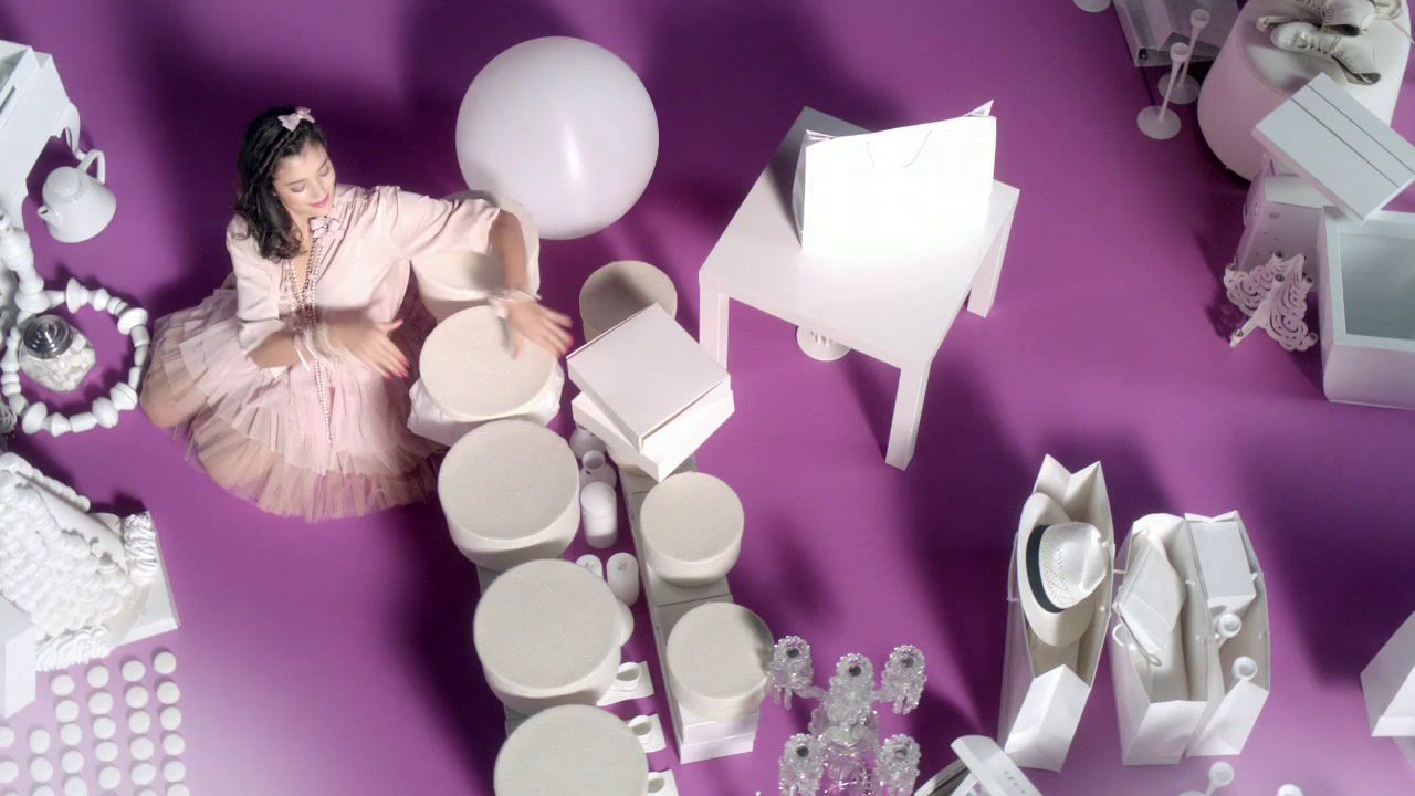 a woman in a pink dress surrounded by white objects