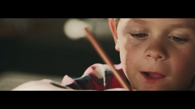 a young boy holding a pair of chopsticks