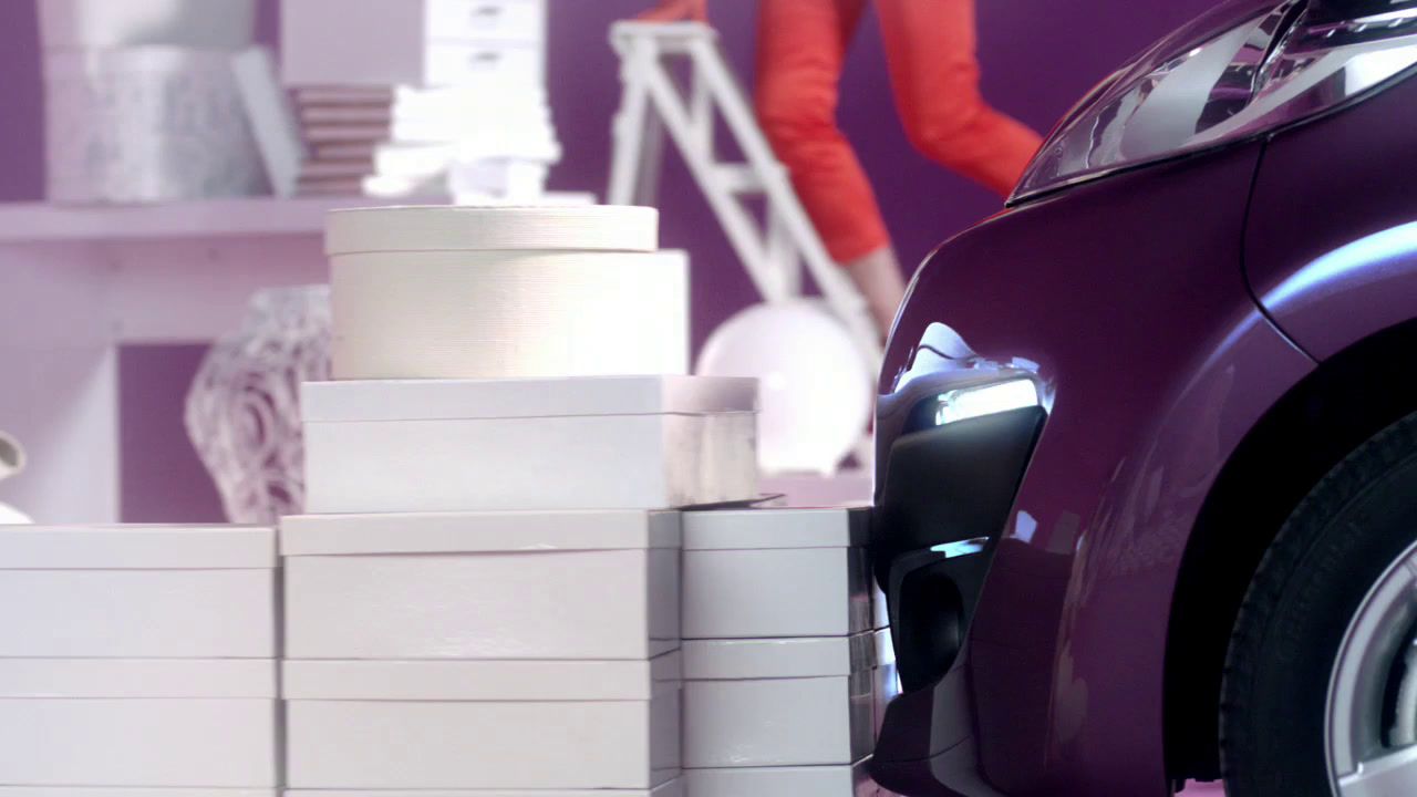 a purple car parked next to a pile of white boxes