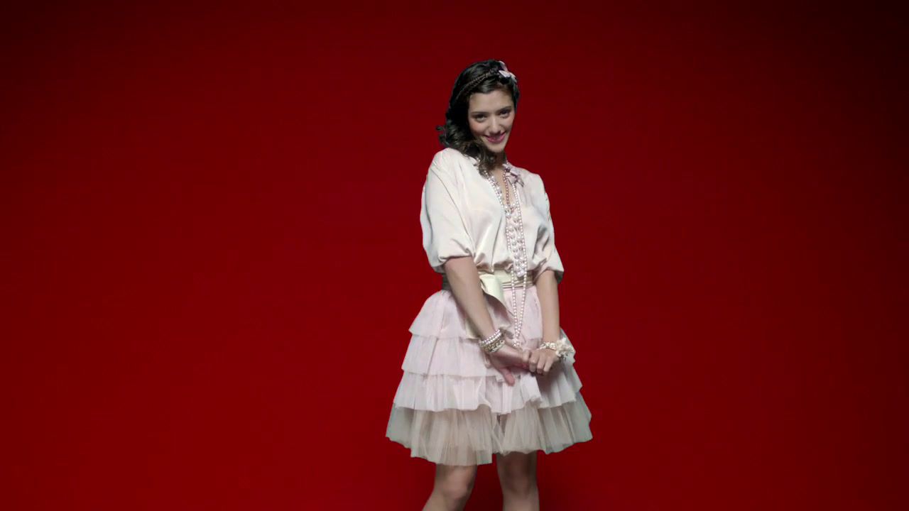 a woman in a pink dress standing in front of a red background