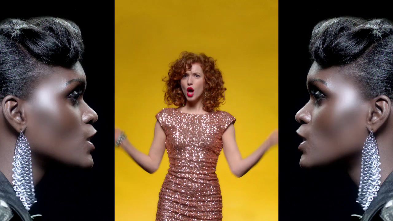 a woman making a funny face while standing in front of a yellow background