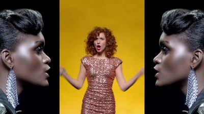 a woman making a funny face while standing in front of a yellow background