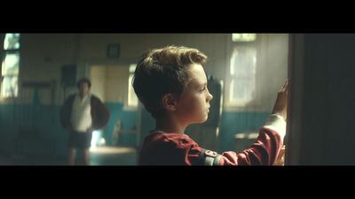 a young boy standing in front of a window