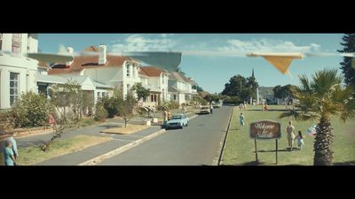 a group of people walking down a street next to houses