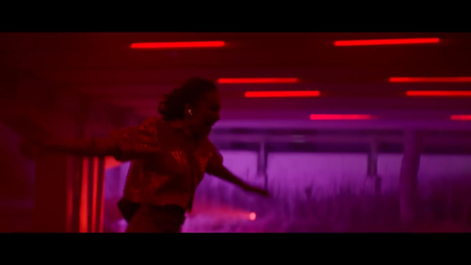 a person standing in a room with red lights