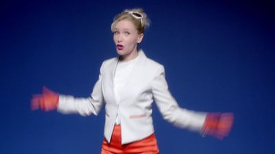 a woman in a white jacket and orange shorts