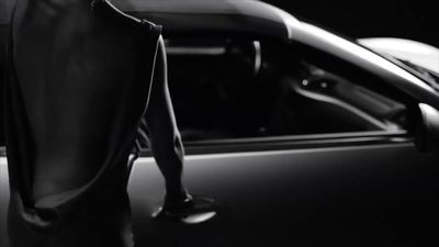 a man standing next to a car in a black and white photo