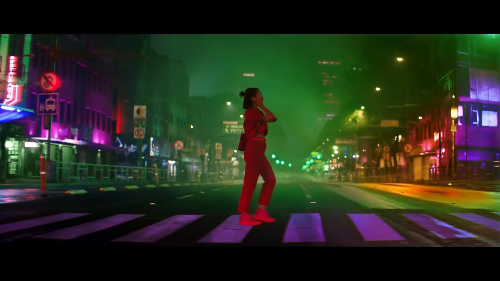 a woman in a red suit is crossing the street