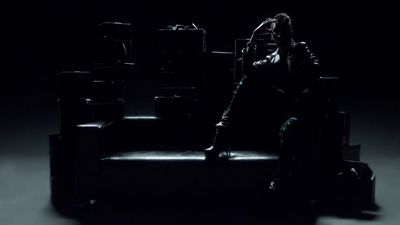 a person sitting on a chair in the dark