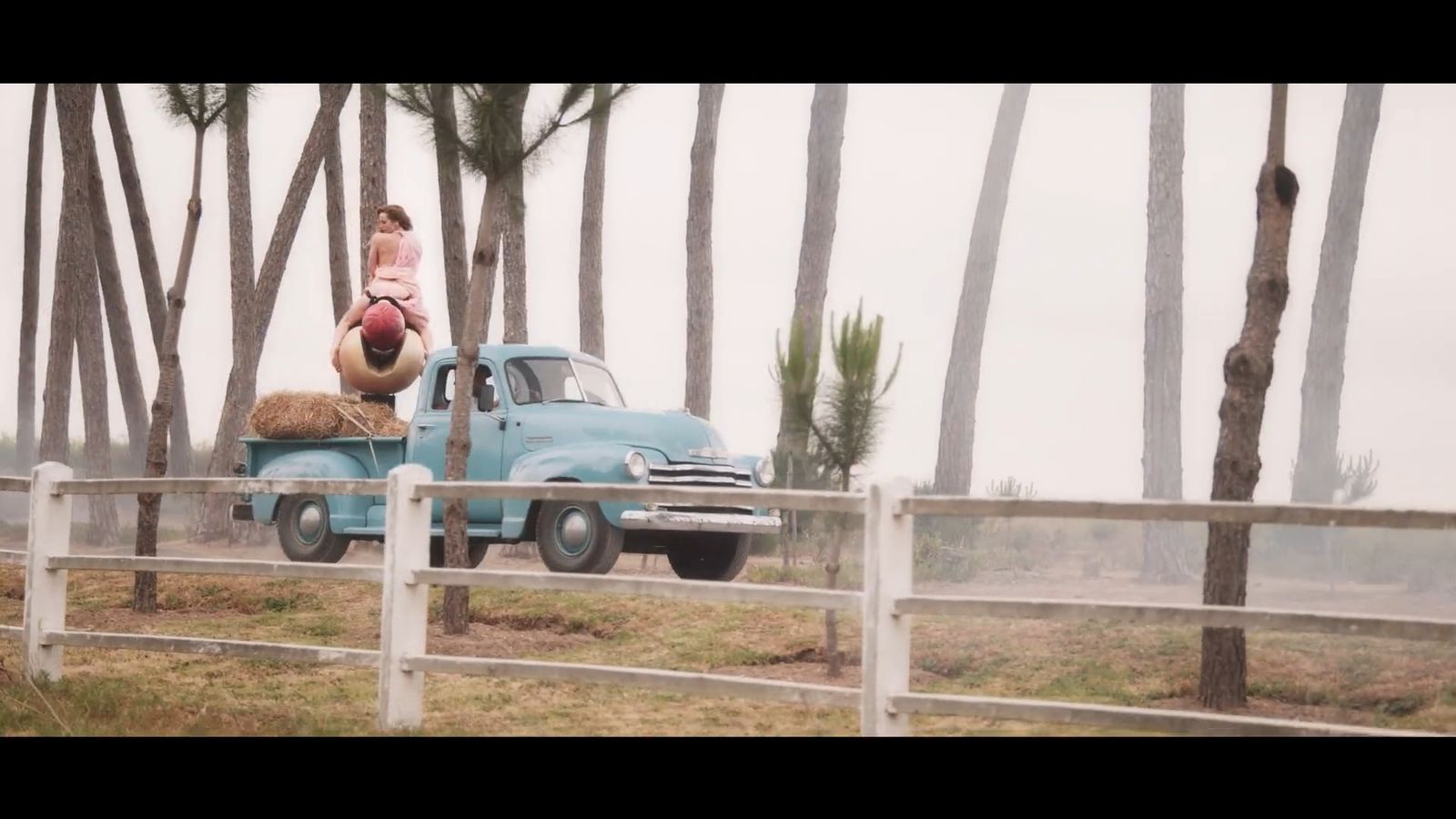 a little girl playing with a stuffed animal on the back of a truck