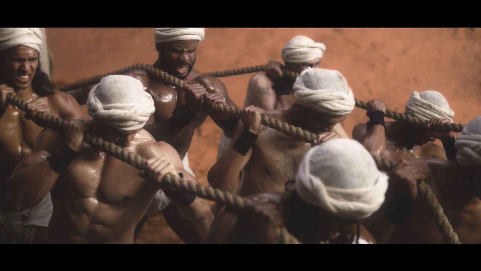 a group of naked men holding onto ropes