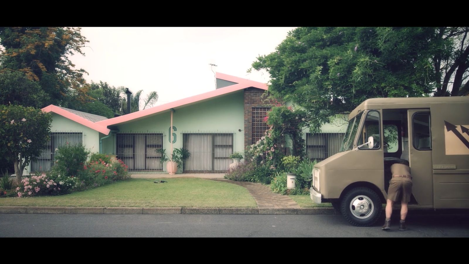 a man standing next to a moving truck in front of a house