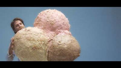 a man holding a giant doughnut in front of a blue sky