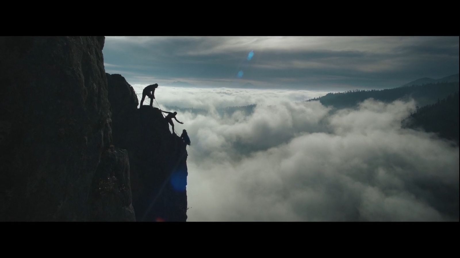 a person standing on top of a cliff with a dog