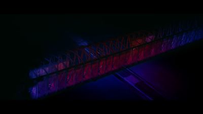 a red and blue bridge lit up at night