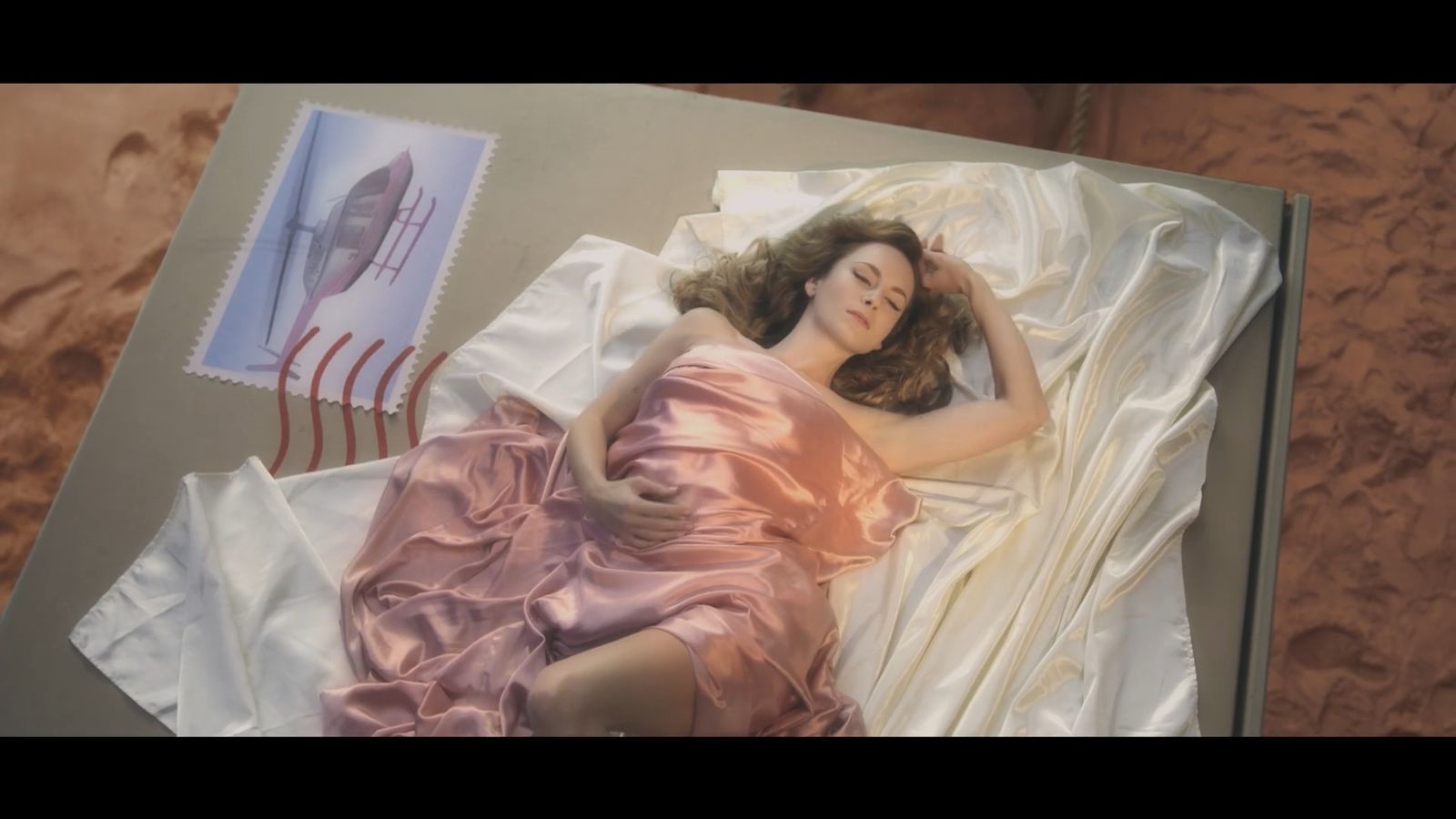 a woman in a pink dress laying in a bed