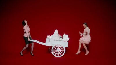 a couple of women that are standing in front of a cart