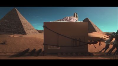 a woman laying on top of a box in the desert