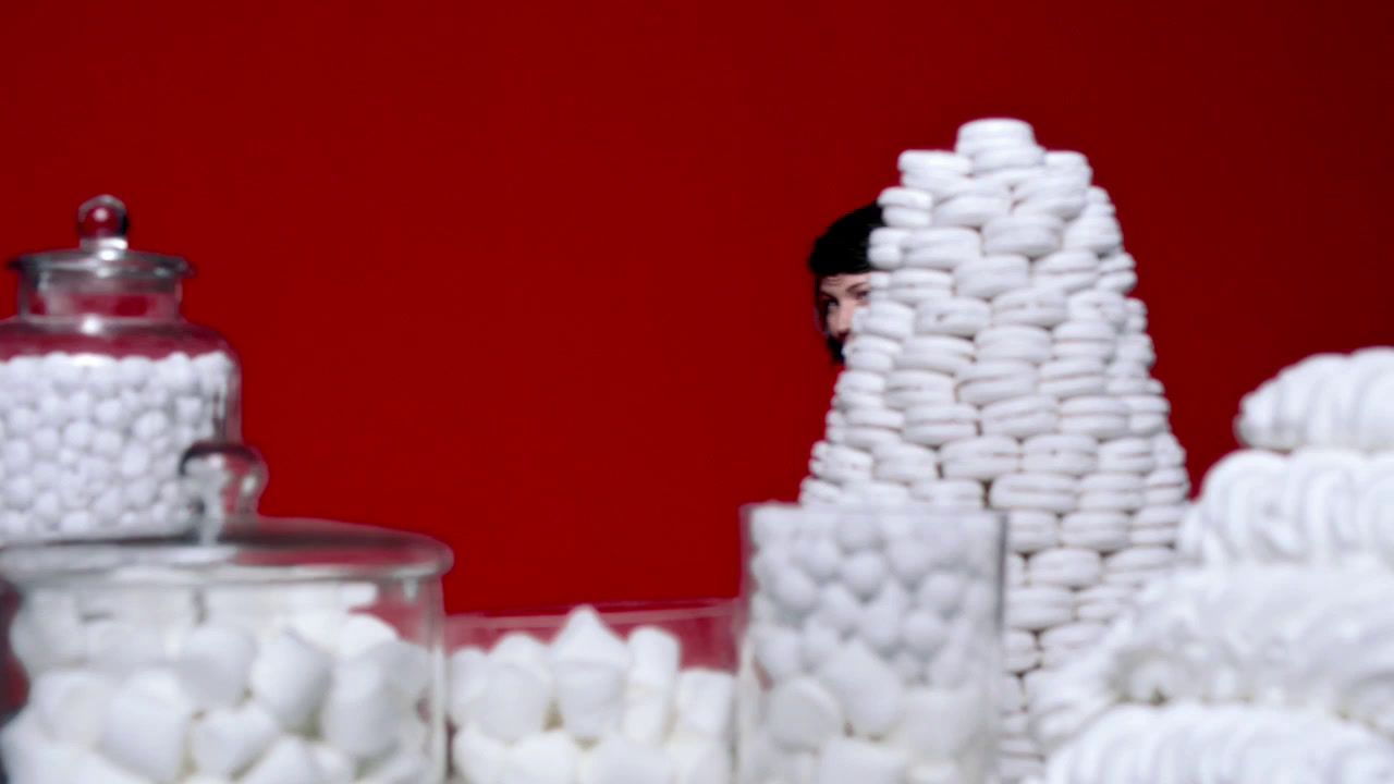 a pile of white marshmallows sitting next to a red wall