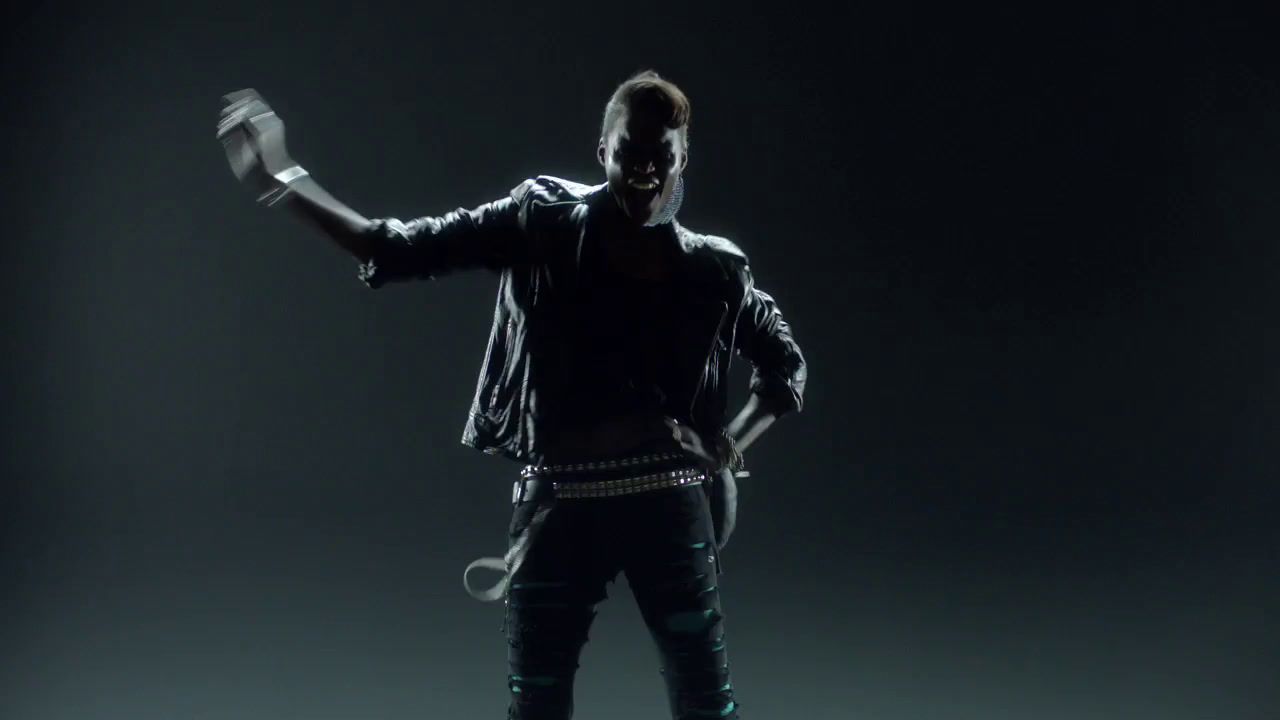 a man in a black leather jacket is dancing