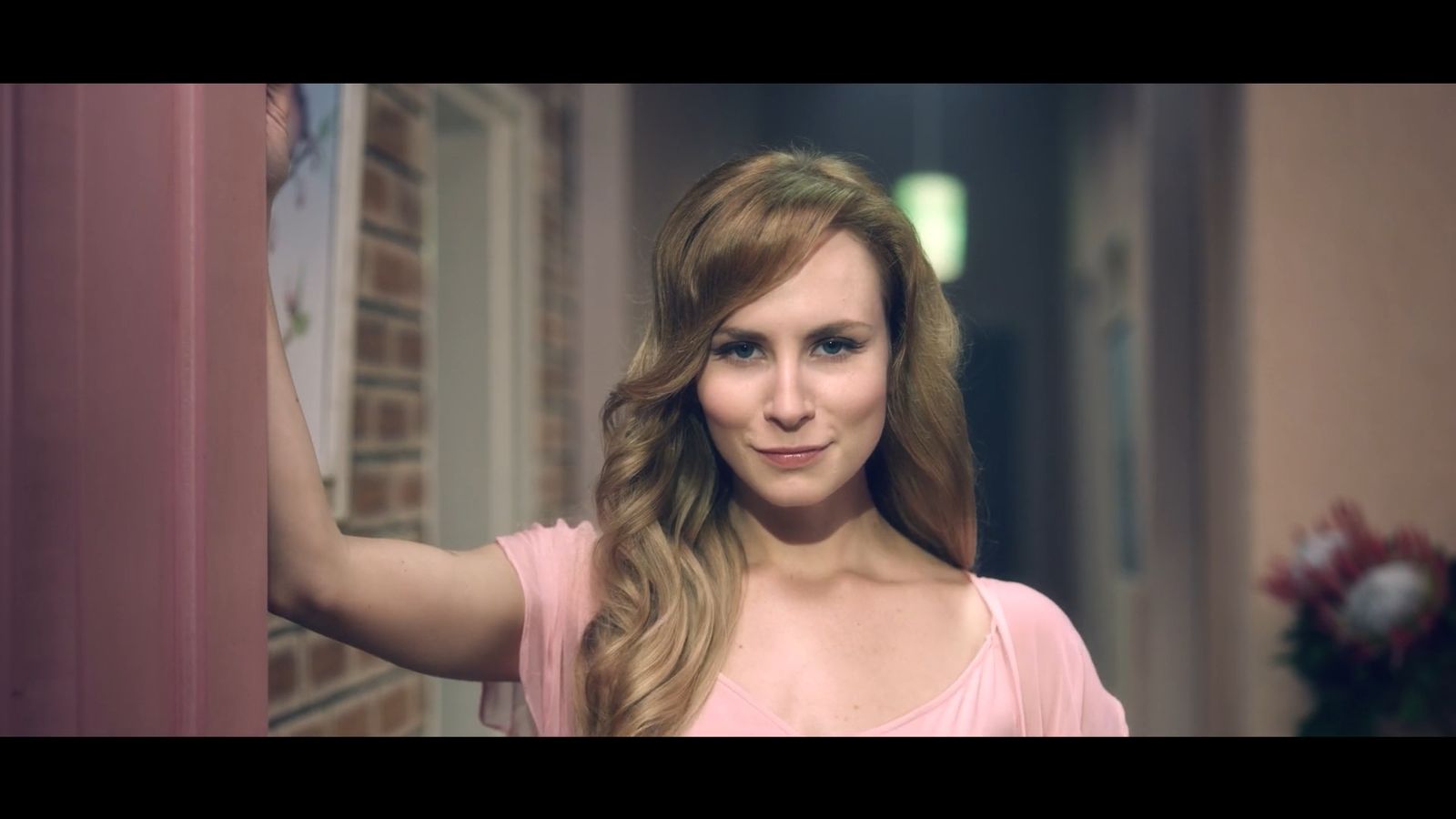 a woman with long hair standing in a hallway