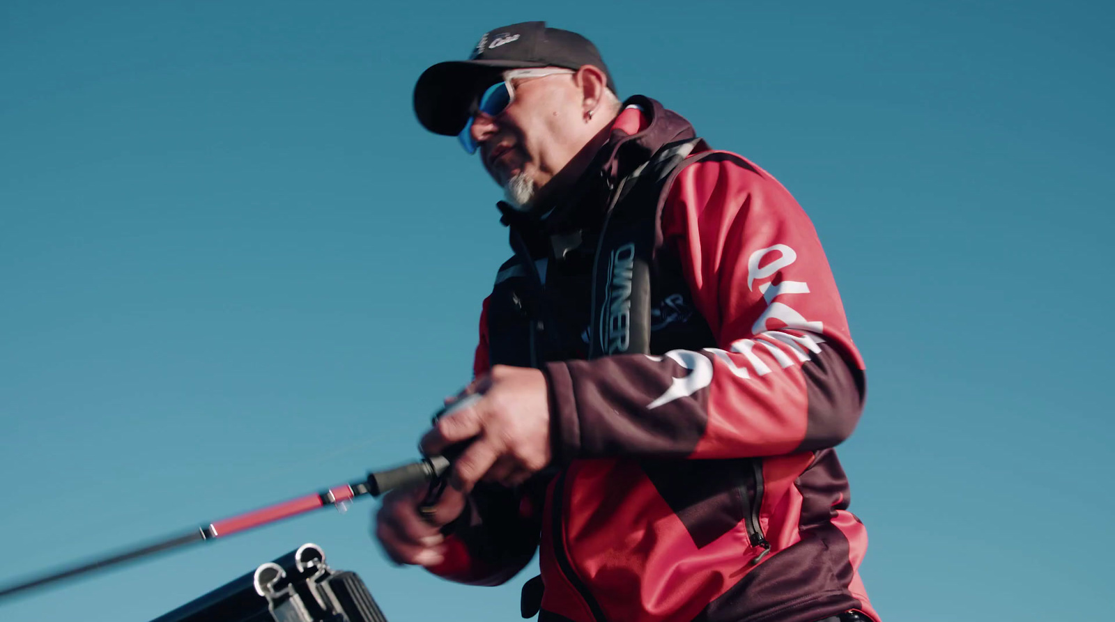 a man in a red jacket holding a fishing pole