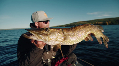 a man on a boat holding a large fish