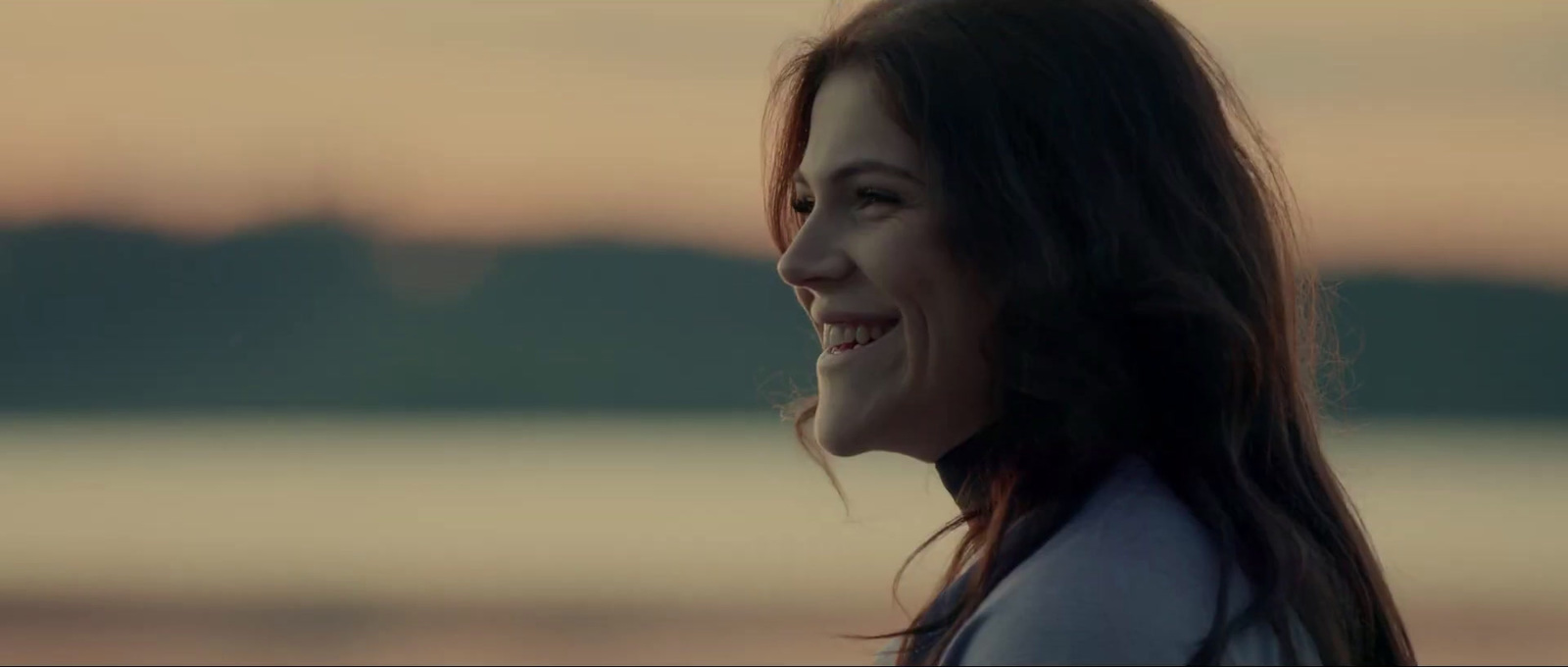 a woman with long hair smiling at the camera