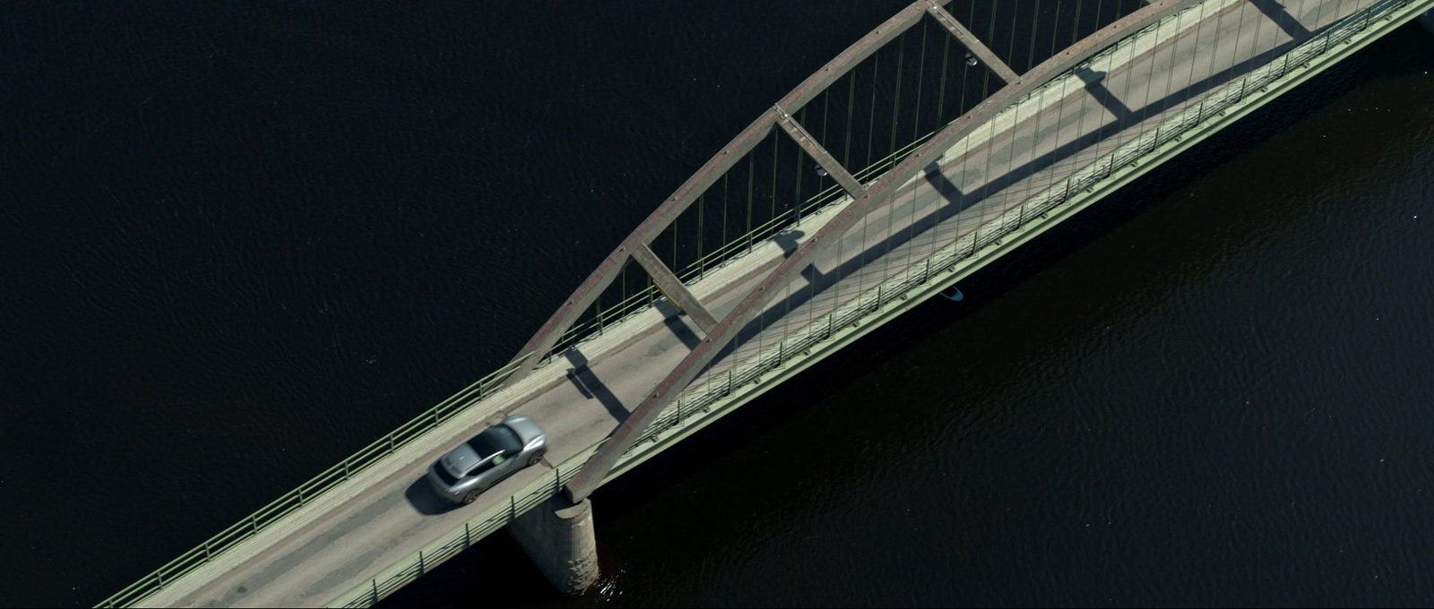 a car driving across a bridge over a body of water