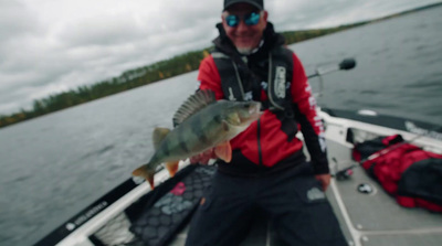 a man on a boat holding a fish