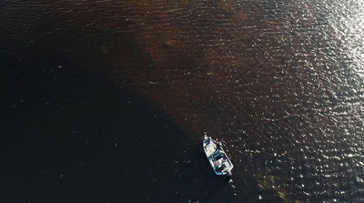 a small boat floating on top of a large body of water