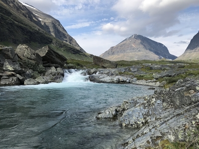 a river running through a lush green valley