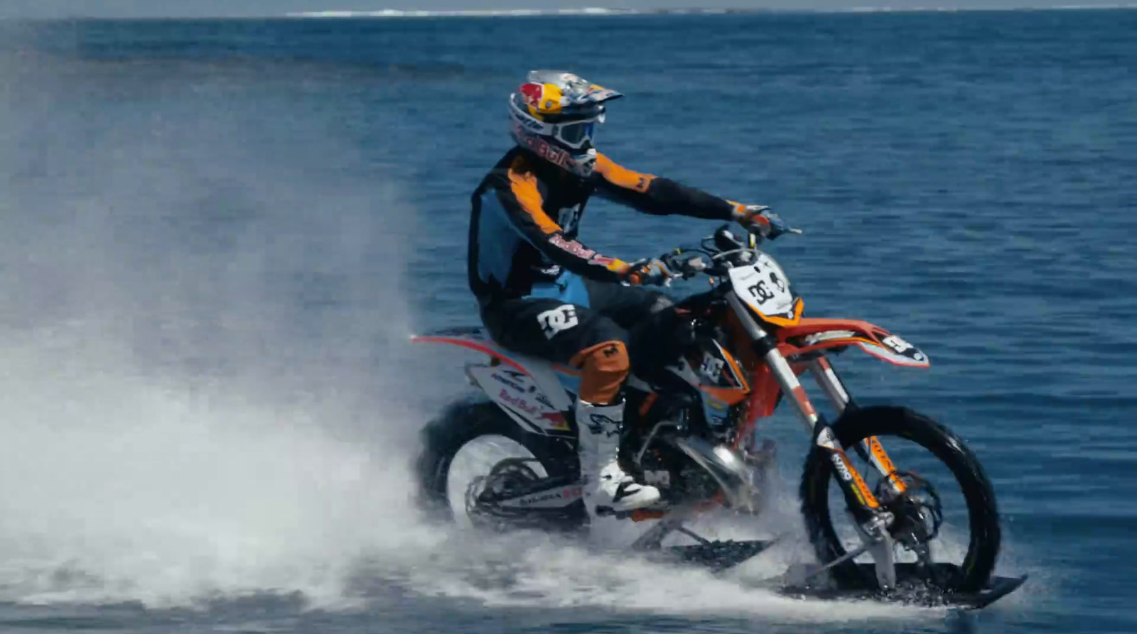 a man riding a motorcycle on top of a body of water